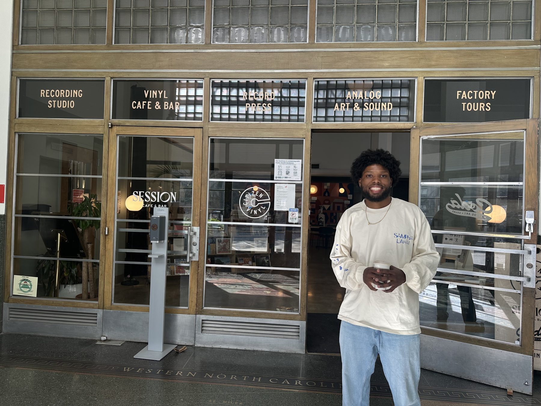 J’lin Rose outside Citizen Vinyl in Asheville, North Carolina, a building housing a recording studio, record press, and vinyl cafe.